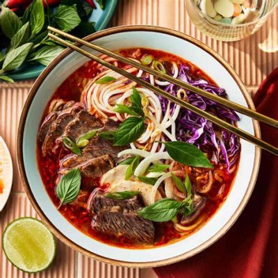 Bún Bò Huế: A Symphony of Spicy Broth and Pillowy Noodles Exploding with Flavor!